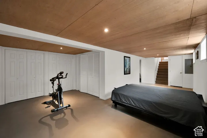 Finished interior space featuring a wood-paneled ceiling, recessed lighting, neutral floor covering, and multiple white louvered-style built-in storage closets