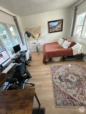 Light-filled room featuring wood-finish flooring and multiple windows with white trim