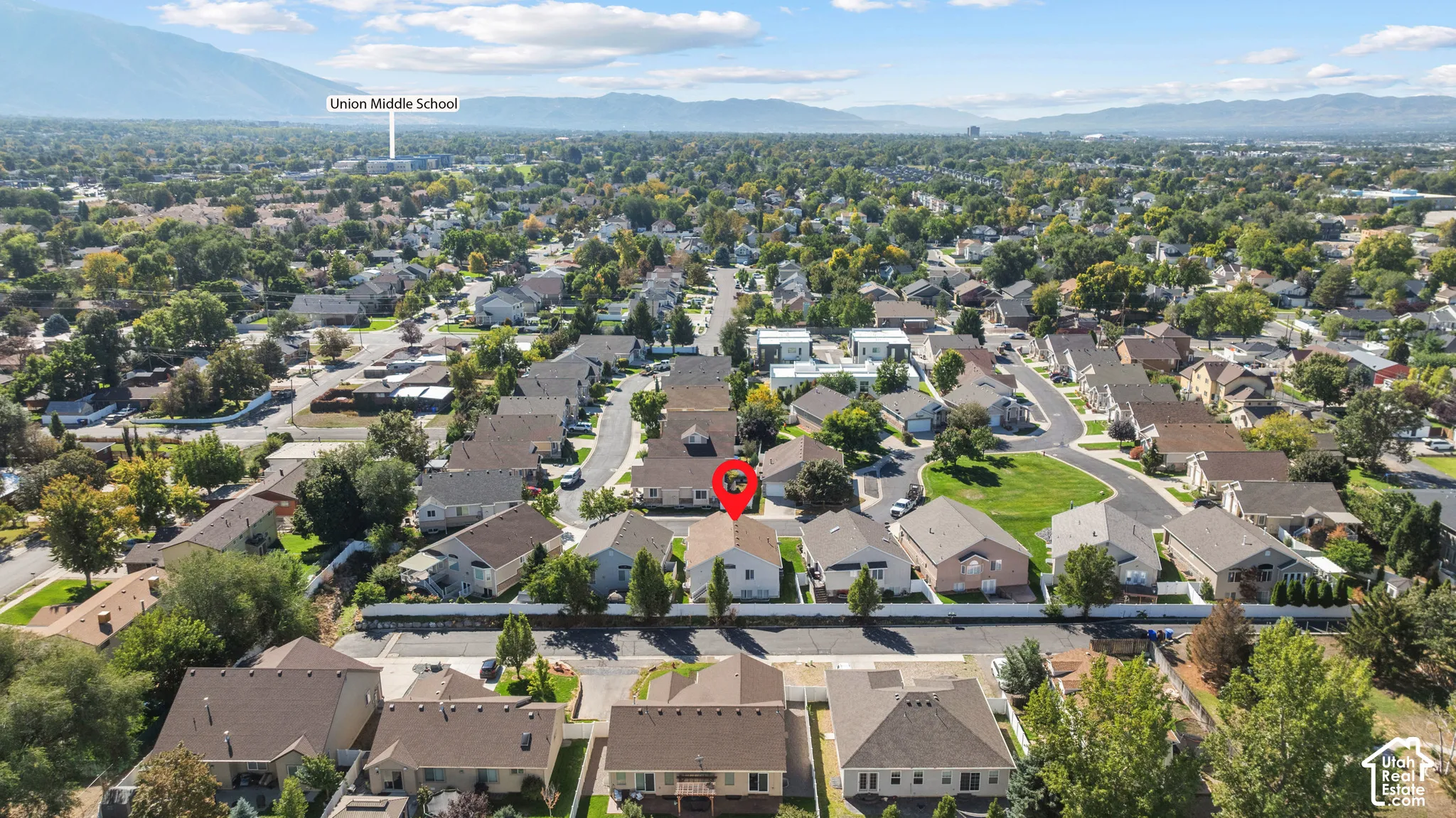 Aerial perspective of the residential property featuring a suburban layout with mountain backdrops and established neighborhood vegetation