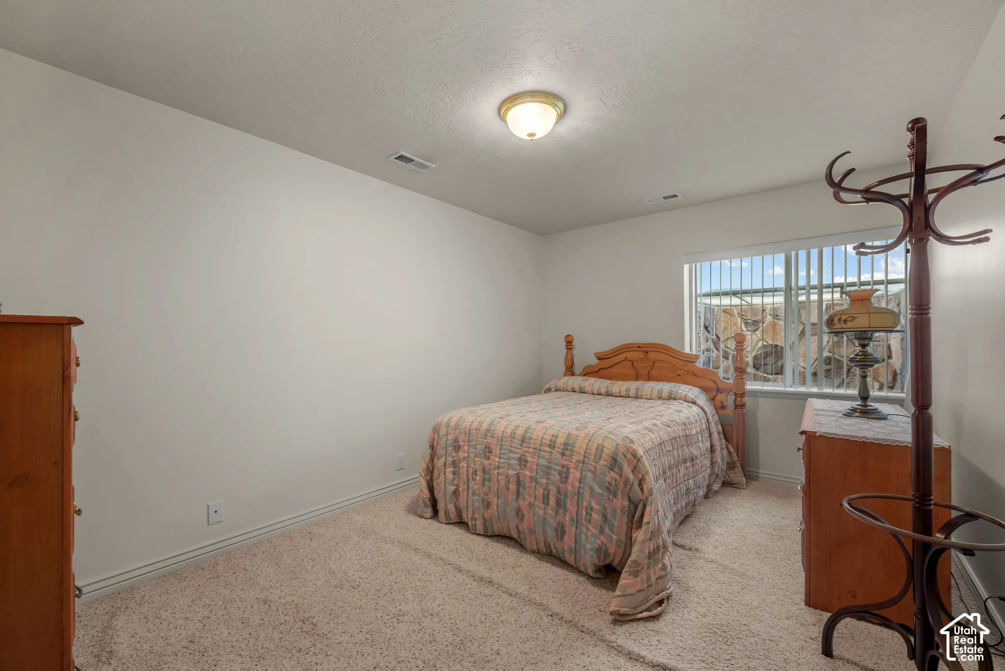 Neutral interior space featuring carpeted flooring, white walls, a center dome ceiling light, and a window with vertical blinds