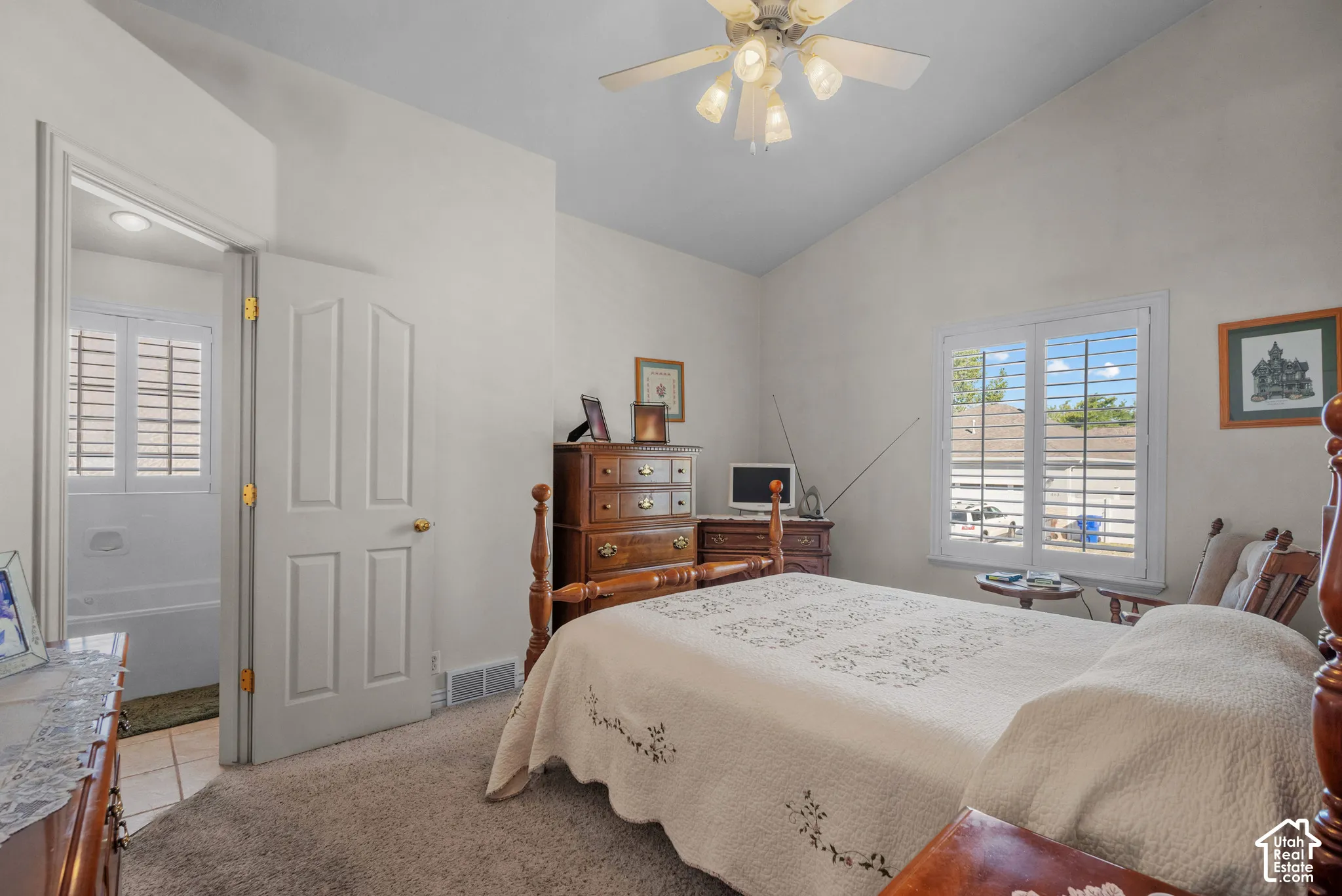 Vaulted ceiling, ceiling fan with multi-light fixture, and plantation shutters