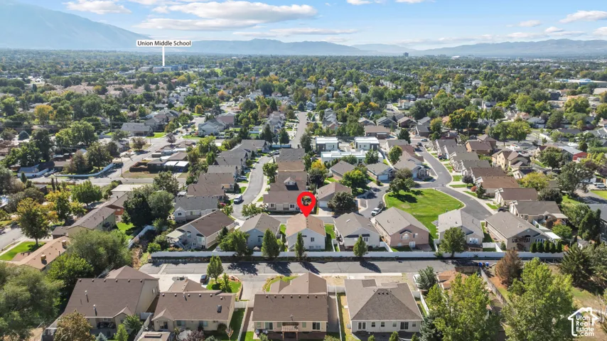 Aerial perspective of the residential property featuring a suburban layout with mountain backdrops and established neighborhood vegetation