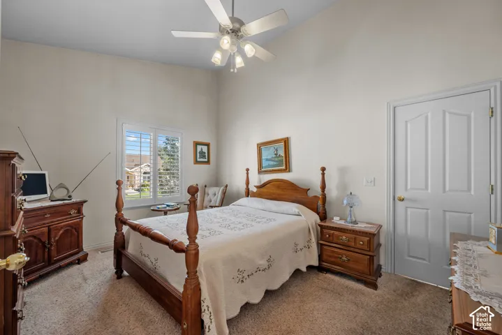 Vaulted ceilings, carpeted flooring, multi-light ceiling fan, plantation shutters, and a six-panel door