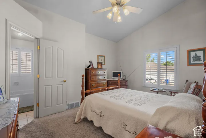 Vaulted ceiling, ceiling fan with multi-light fixture, and plantation shutters