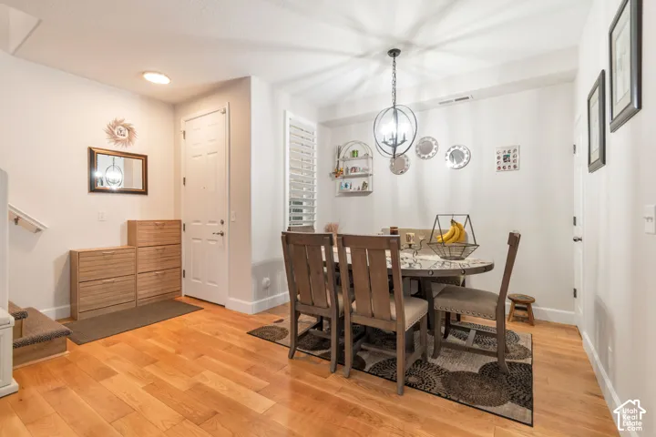 Wood-finish flooring, orb-style pendant lighting, plantation shutters, and a six-panel entry door