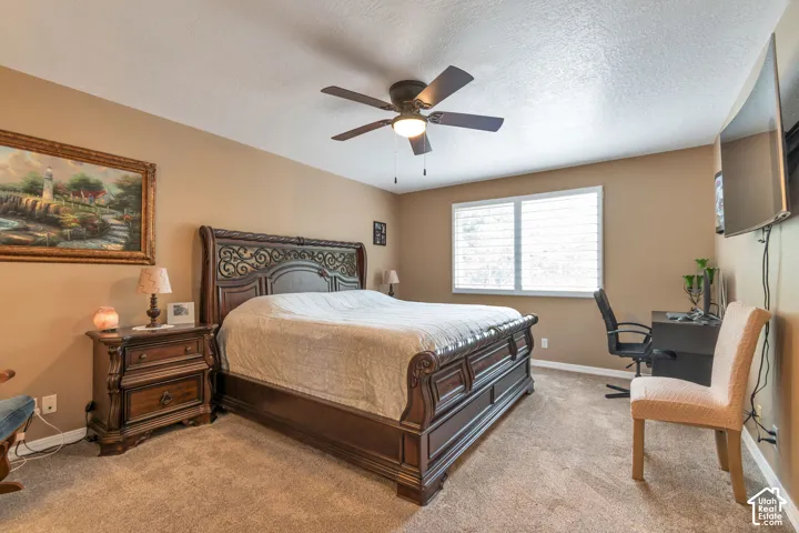 Neutral-toned interior featuring carpeting, a ceiling fan with integrated lighting, and window shutters