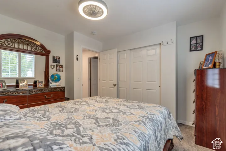 Neutral-toned room featuring a ceiling-mounted LED light fixture, sliding closet doors with raised panels, and wall-mounted hooks