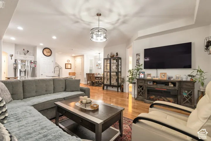Open-concept interior featuring wood-finish flooring, recessed lighting, and a drum-style ceiling light fixture with metal accents