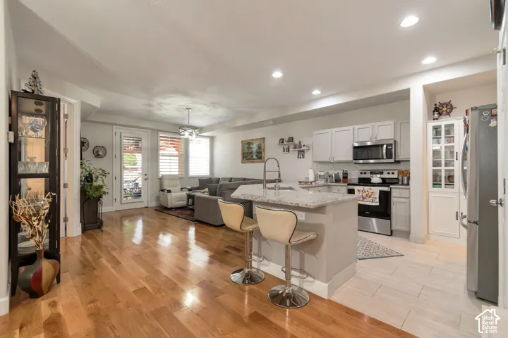 Kitchen featuring a stone-surface island, stainless steel appliances, and white cabinetry