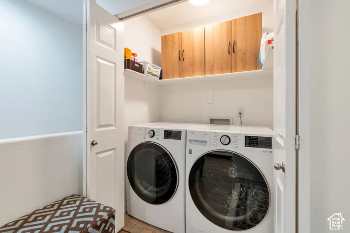 Laundry closet featuring built-in wood-finish cabinetry and overhead shelving