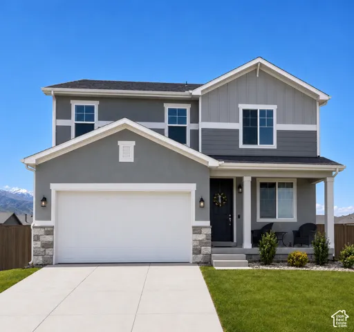 Two-story exterior featuring a mix of horizontal siding and stucco, decorative stone veneer accents, an attached two-car garage, and a covered front porch with square columns