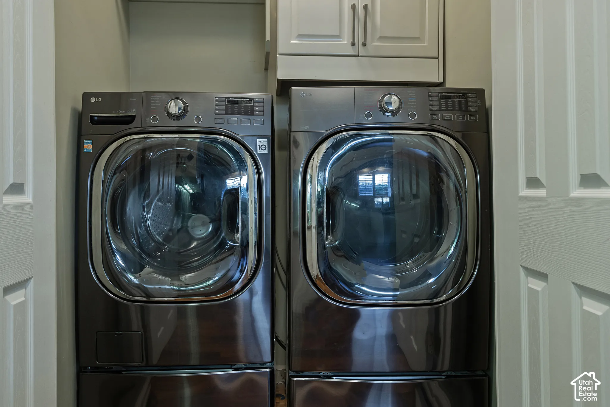 Front-loading washer and dryer set with an overhead storage cabinet