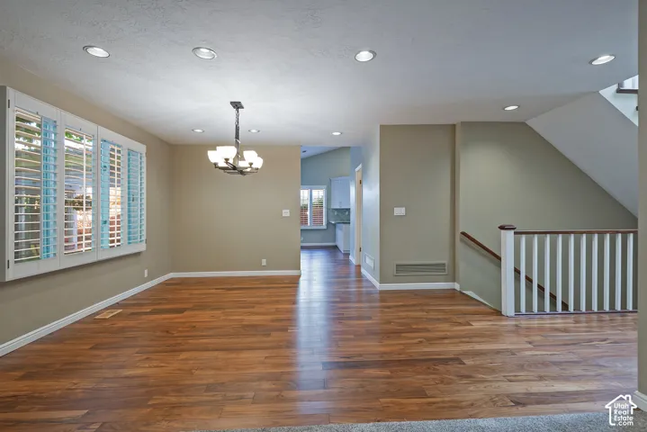 Wood-finish flooring throughout, recessed lighting, and a contemporary chandelier