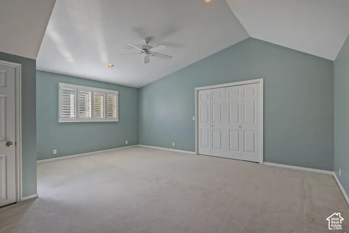Vaulted ceilings, a ceiling fan, recessed lighting, and plantation shutters