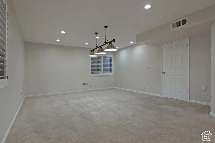 Recessed ceiling lighting, a three-light linear pendant fixture, carpeted flooring, and white interior doors