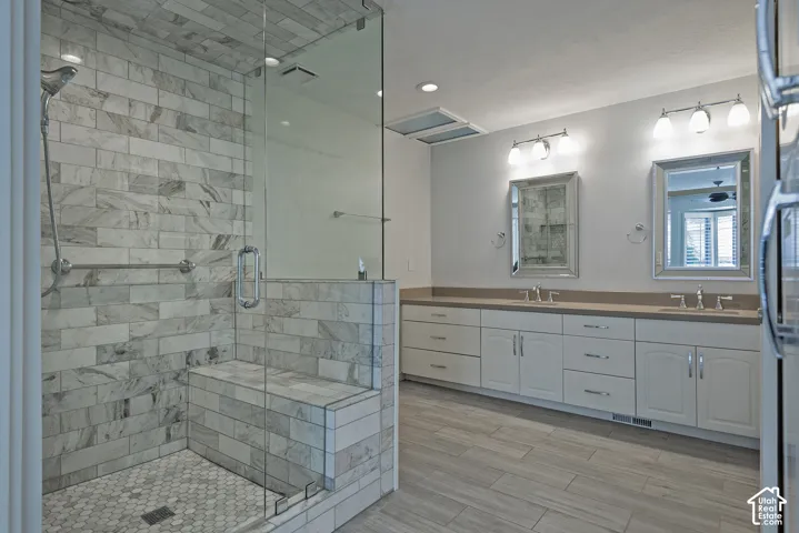 Walk-in shower with stone-look tile, glass enclosure, and built-in bench