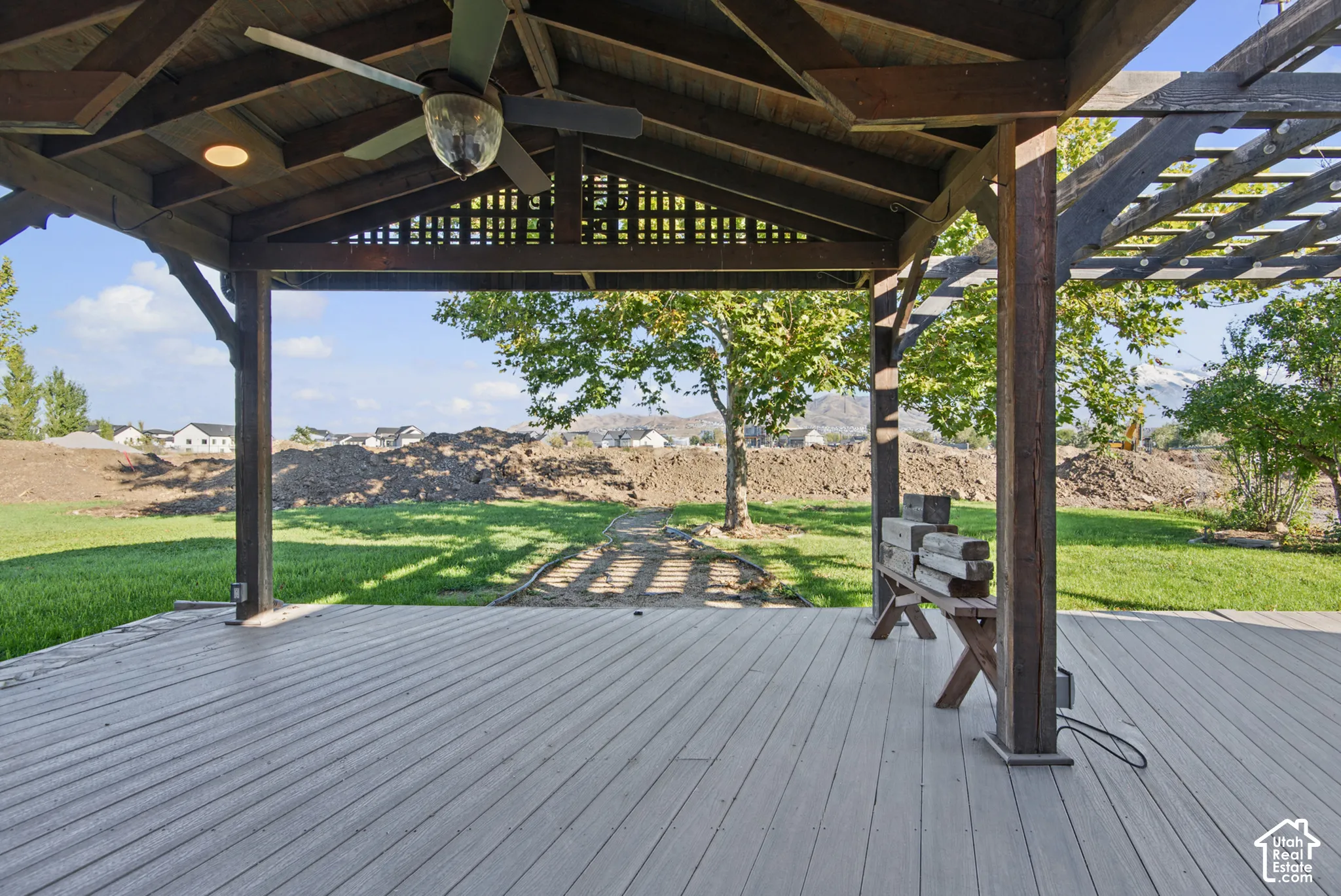 Covered outdoor patio featuring a wood-beam vaulted ceiling, integrated ceiling fan, recessed lighting, and an attached timber-frame pergola