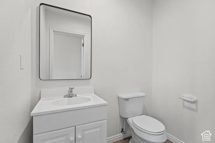 Bathroom featuring a white vanity cabinet with an integrated basin, a single-handle chrome faucet, and a rectangular mirror with a black frame