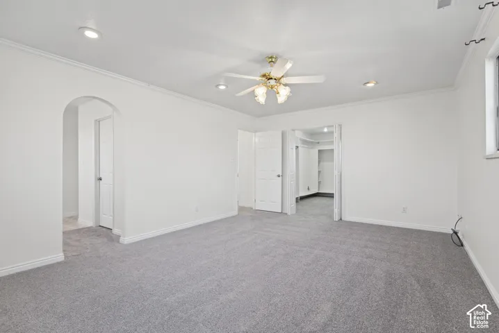 Interior space featuring carpeting, recessed lighting, a ceiling fan with integrated light fixture, an arched entryway, and a closet with bifold doors