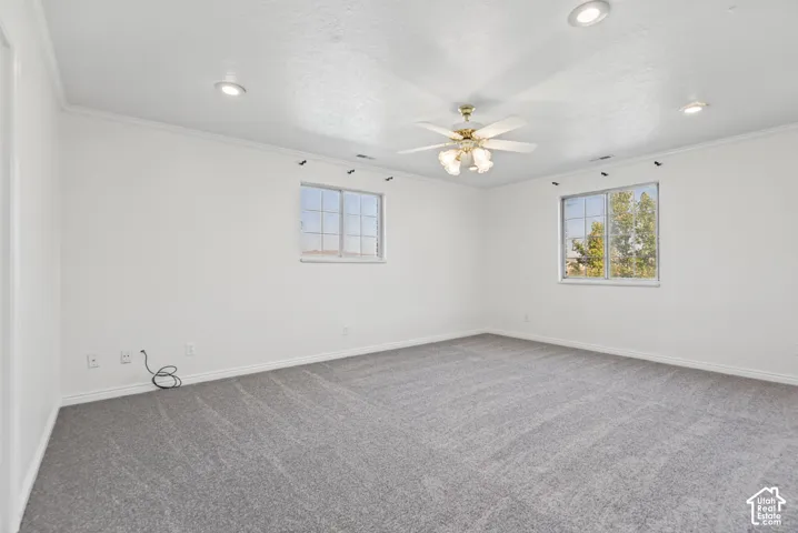 Neutral interior space featuring neutral carpeting, recessed ceiling lighting, a multi-light ceiling fan, and dual pane windows