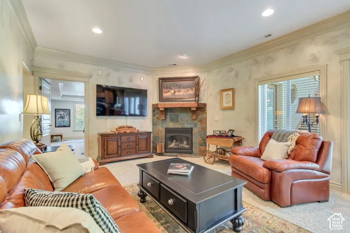 Corner fireplace with slate-tile surround, heavy timber mantel, recessed ceiling lighting, and crown molding