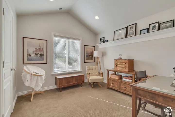 Vaulted ceiling, recessed lighting, built-in display ledge, and window with white trim