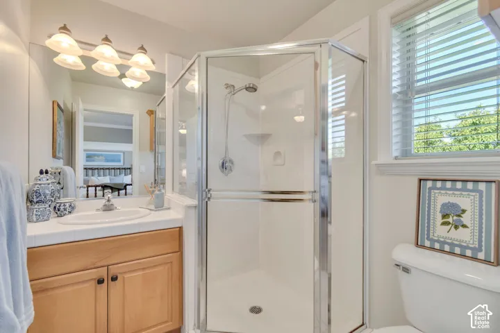 Corner shower with chrome-finished hardware, tile-top vanity, integrated sink, and multi-bulb wall lighting