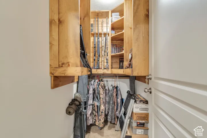 Custom storage closet featuring built-in wood shelving, vertical wall-mounted display racks, and integrated hanging rods