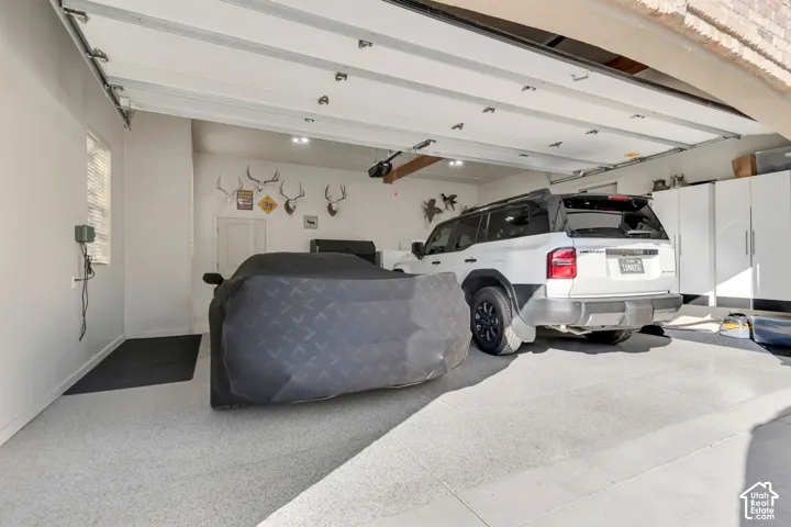 Multi-car garage featuring a coated epoxy floor finish and built-in floor-to-ceiling cabinetry