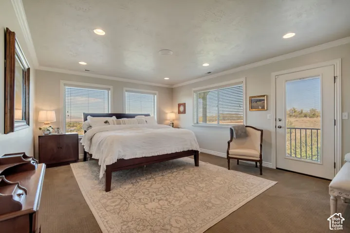 Master Bedroom. Spacious room featuring neutral carpeting, recessed lighting, crown molding, multiple windows with blinds, and a glass-paneled exterior door