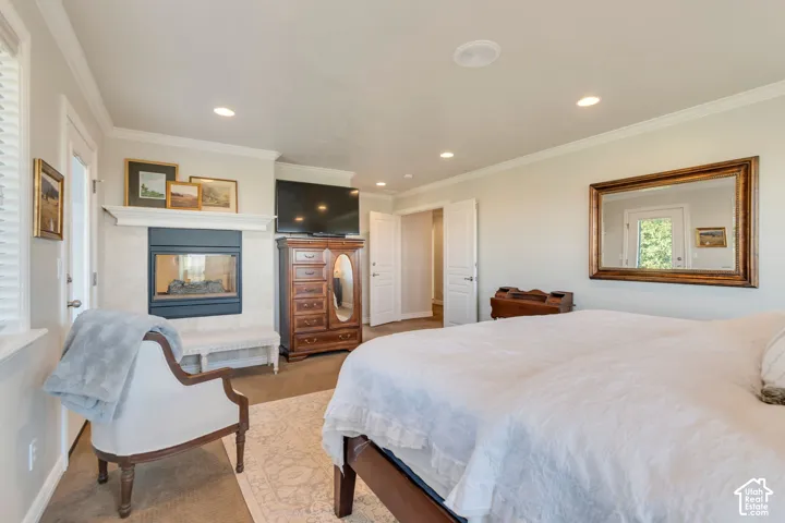 Fireplace with a mantel, recessed lighting, crown molding, and two-panel interior doors