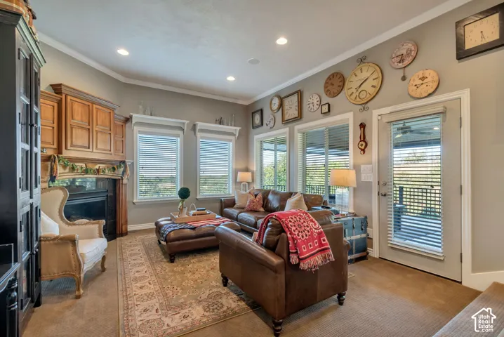 Gas fireplace with a wood mantel, crown molding, built-in cabinetry, recessed lighting, and multiple windows