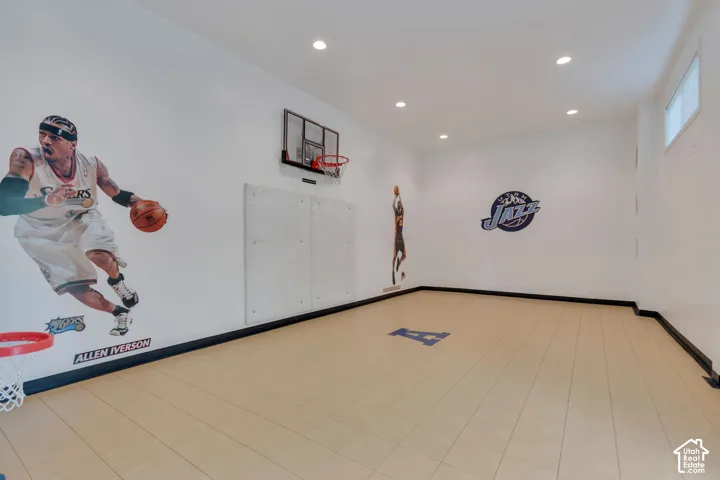 Recreation room featuring recessed lighting, tile flooring, wall-mounted basketball hoop, and padded wall guards