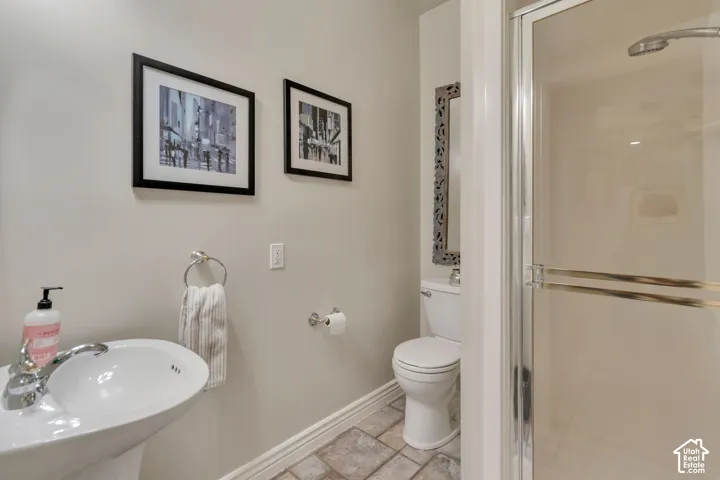 Bright and functional bathroom featuring a round ceramic sink with chrome faucet, white toilet, tile flooring, and framed wall art
