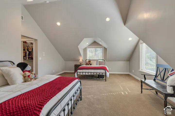 Vaulted ceilings with recessed lighting, dormer window, neutral wall-to-wall carpeting, and walk-in closet