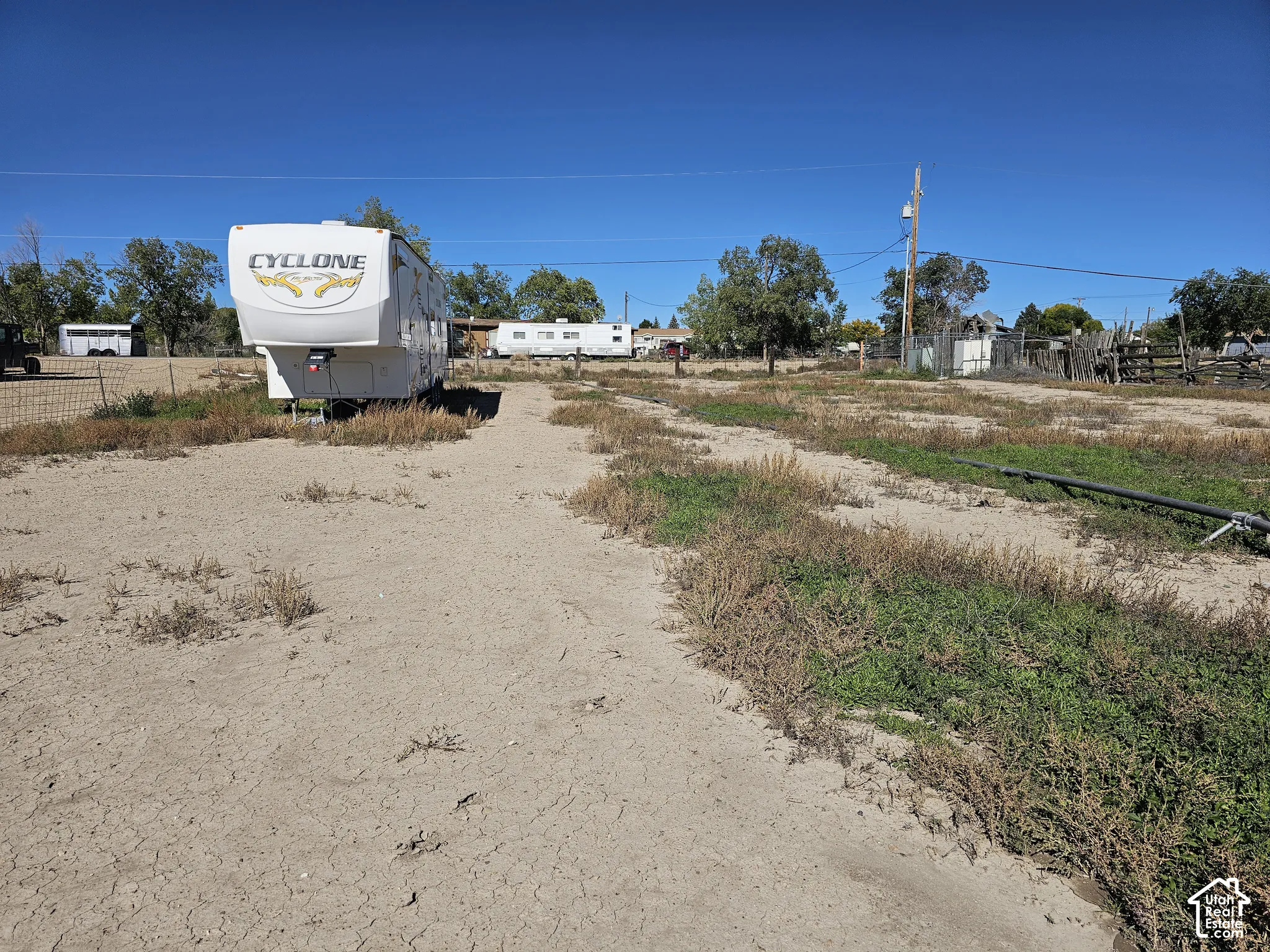 Expansive lot featuring perimeter wire fencing, natural desert landscaping, and utility infrastructure
