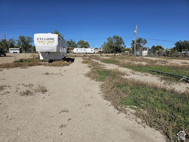 Expansive lot featuring perimeter wire fencing, natural desert landscaping, and utility infrastructure