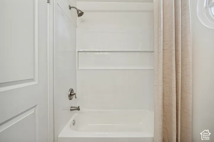 Bathtub with a white subway tile surround, integrated horizontal wall niche, and brushed nickel hardware