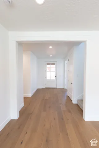 Entryway featuring wood-finish flooring, recessed lighting, and a multi-pane glass entry door framed with flat-profile casing