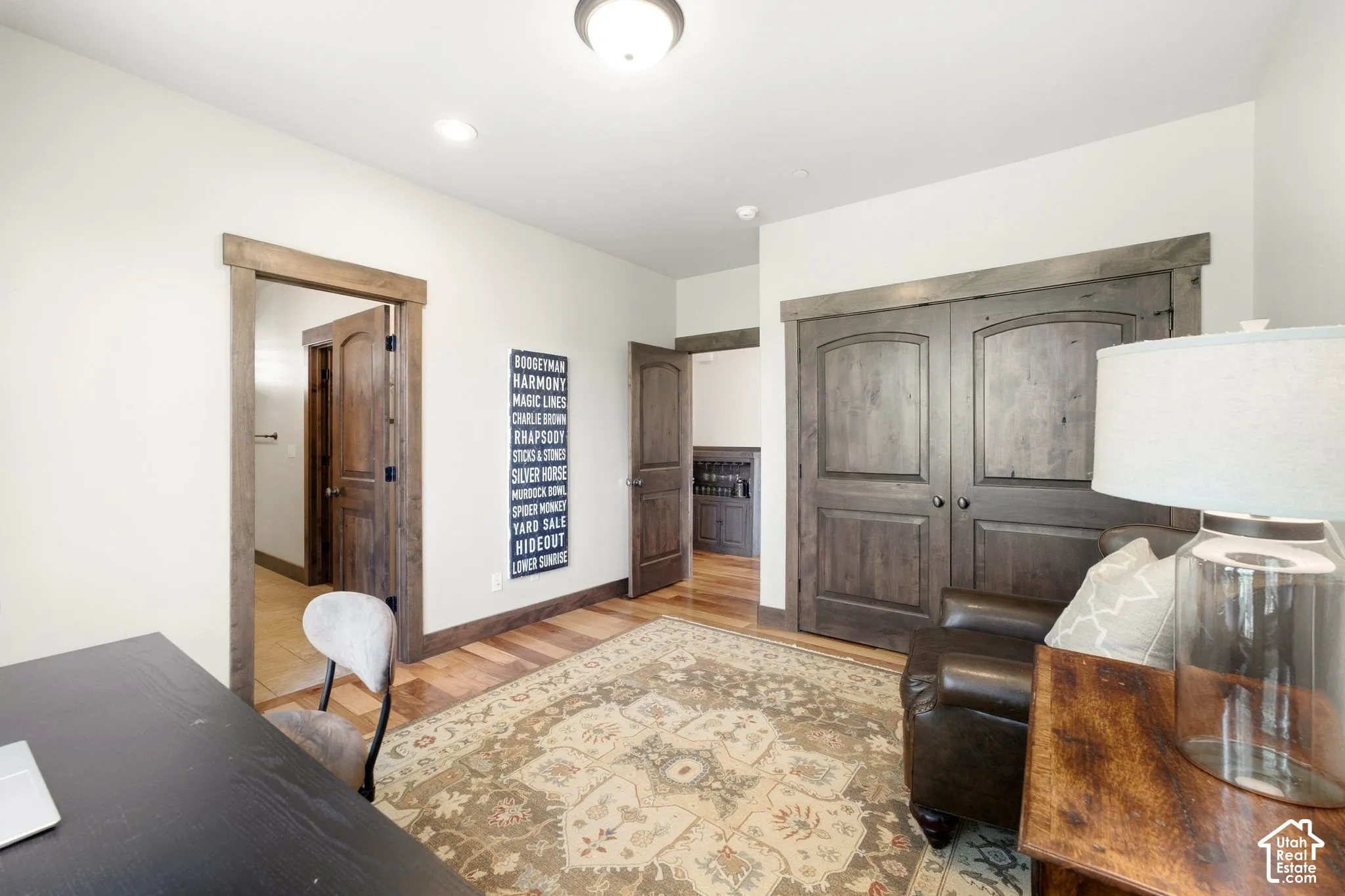 Stained-wood interior doors with matching casing and header trim, hardwood flooring, and neutral wall paint