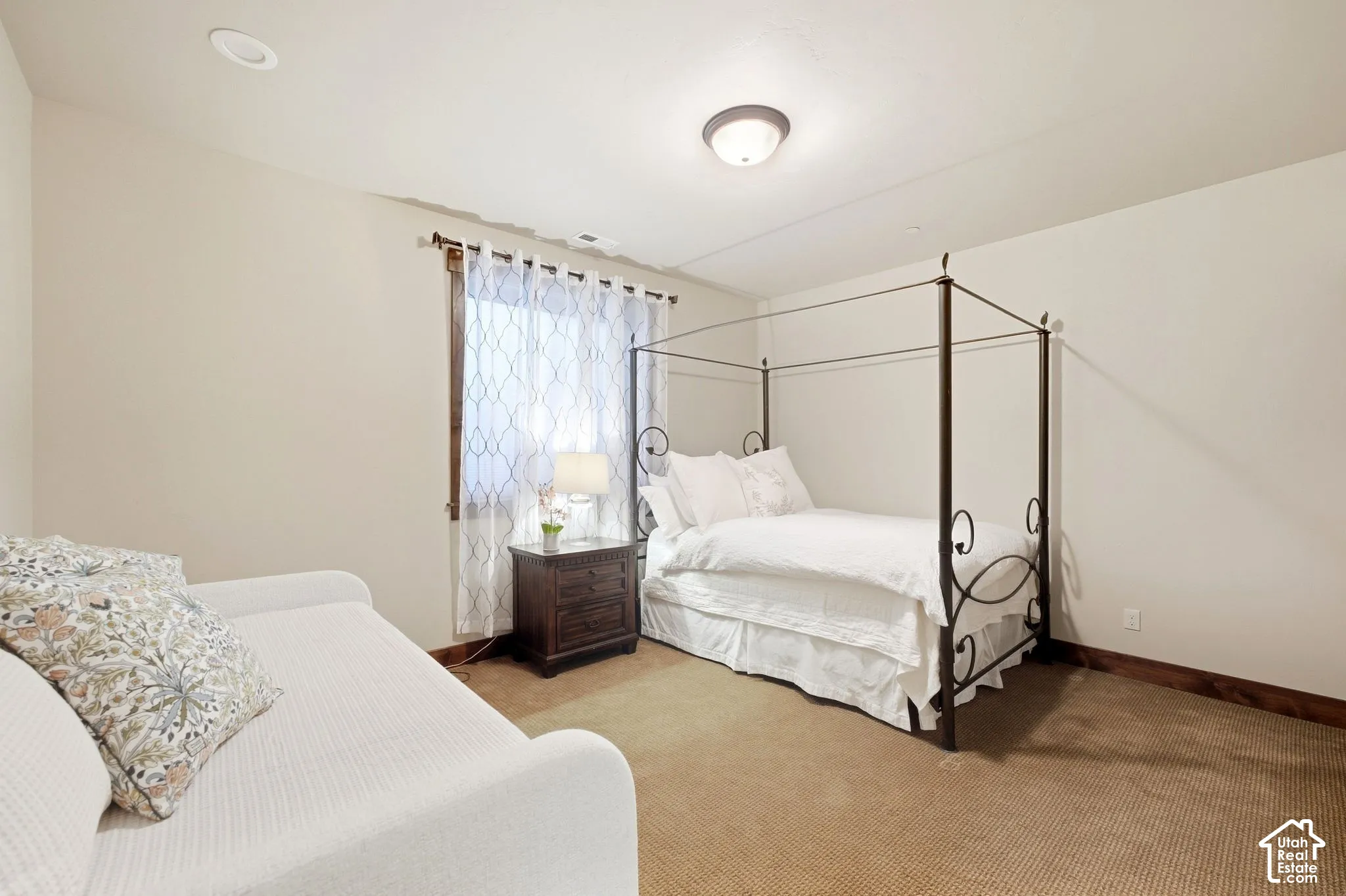 Neutral wall tones, carpeted flooring, recessed lighting, flush-mount ceiling fixture, and a window with wood-trim casing