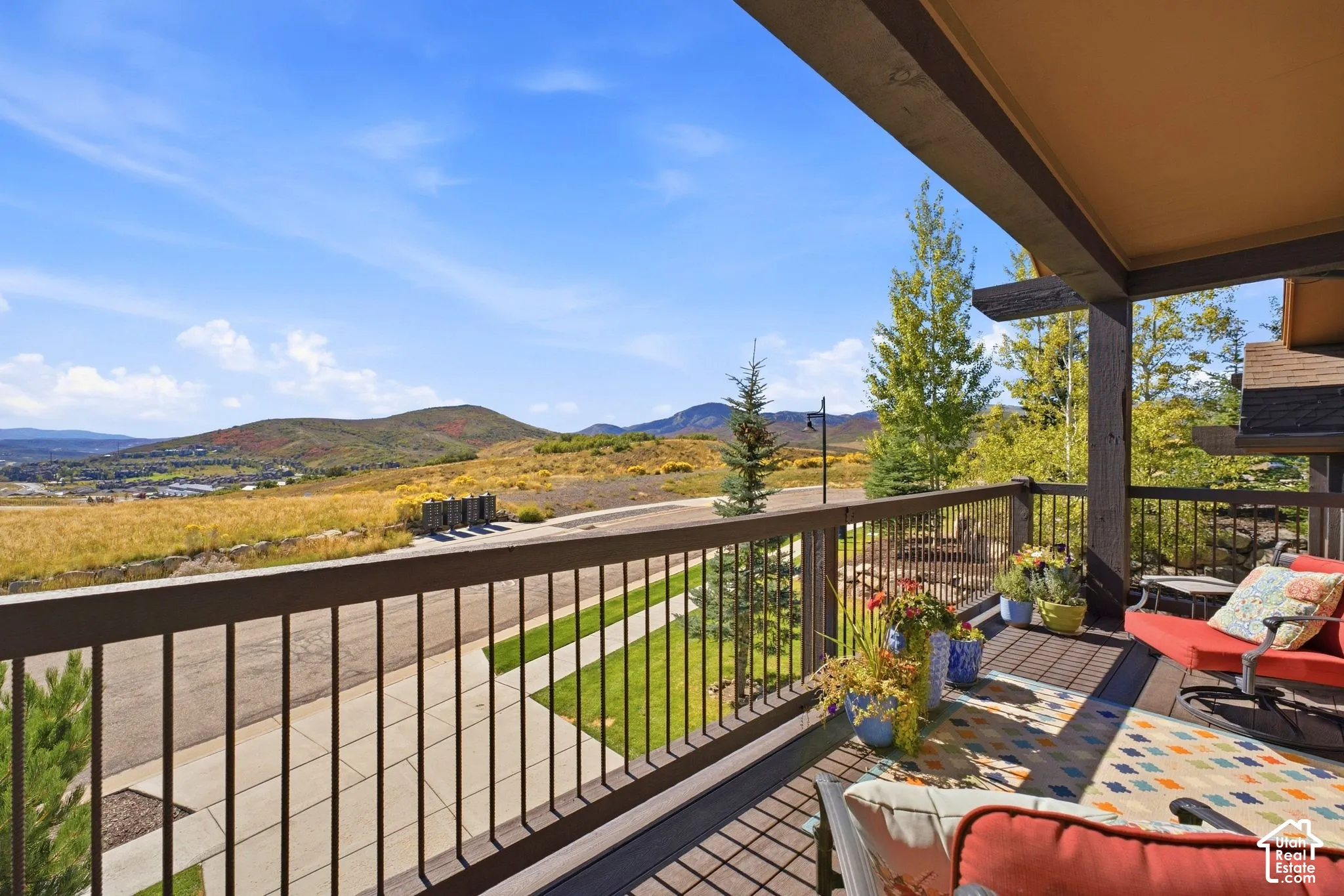 Covered balcony featuring dark-finished wood and metal railings and a mountain landscape backdrop