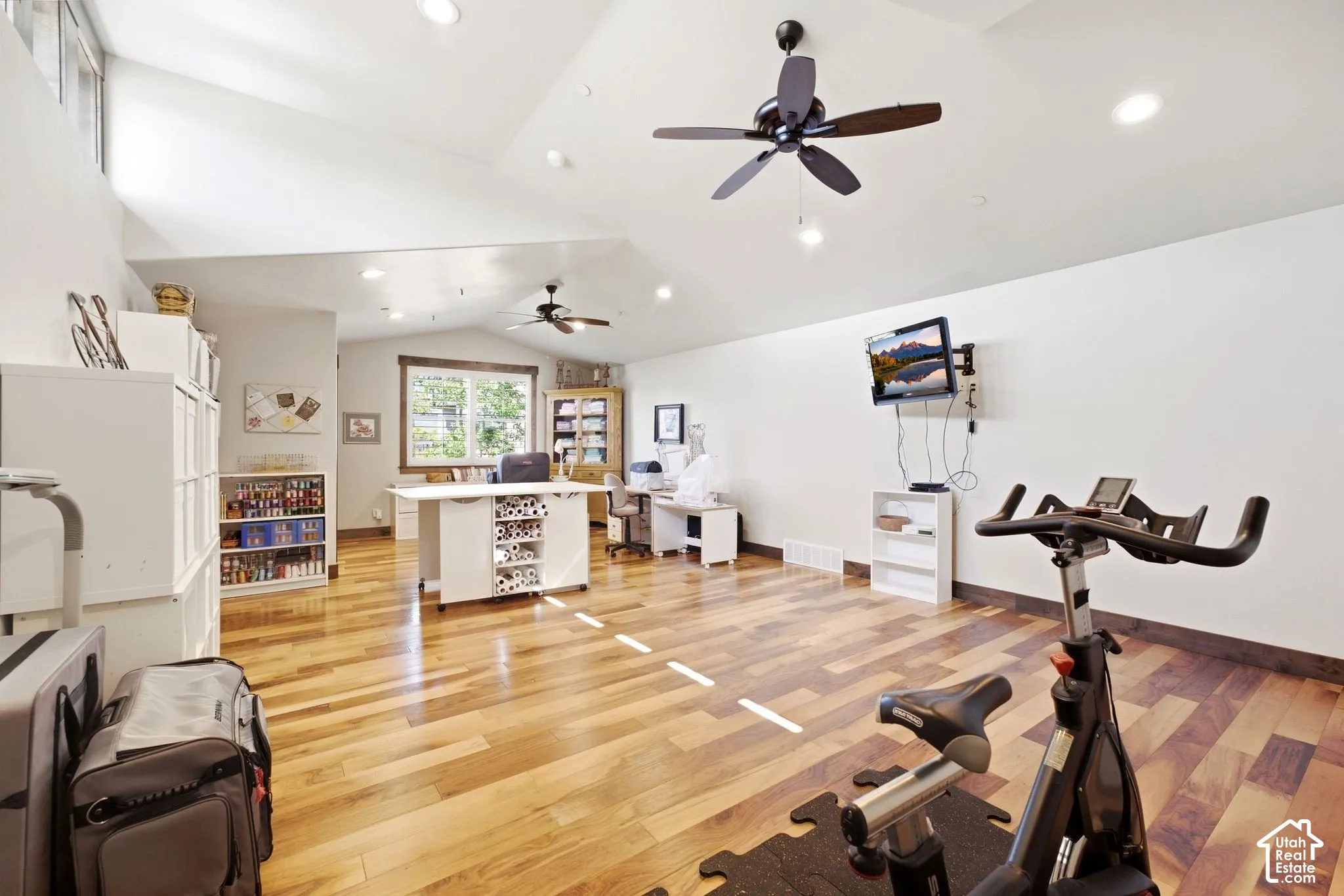 Vaulted ceiling featuring recessed lighting, dual ceiling fans, wood-finish flooring, and expansive wall space