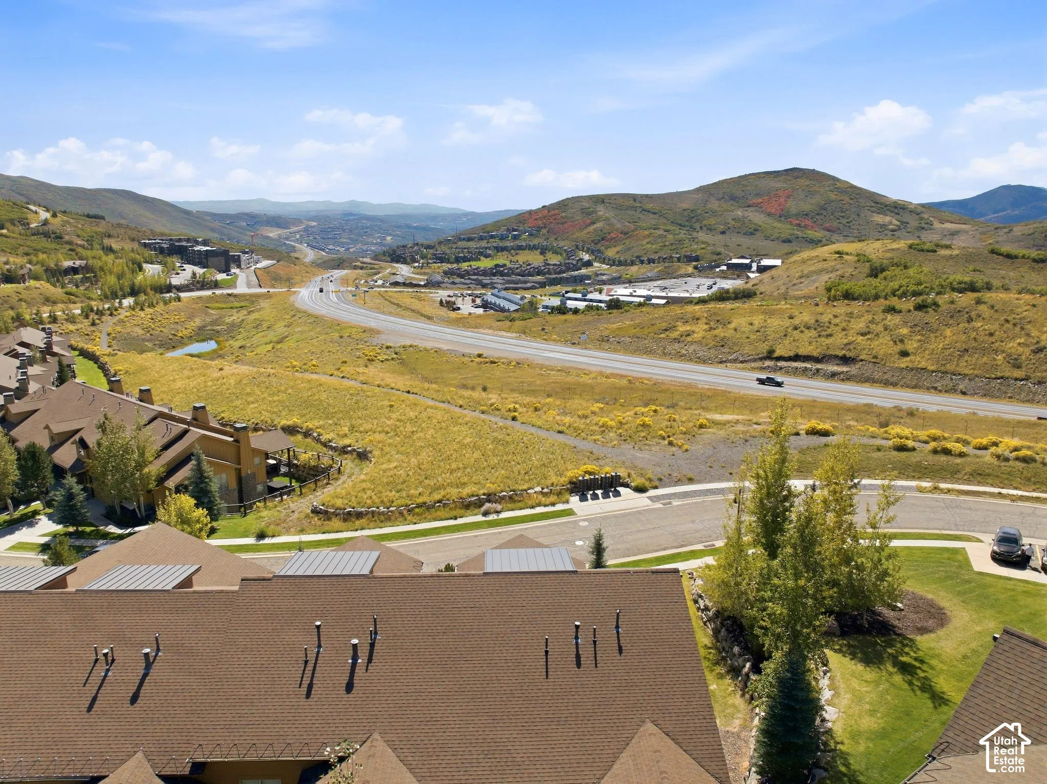 Aerial perspective featuring multi-level asphalt shingle roofing, integrated chimneys, and expansive surrounding mountain terrain