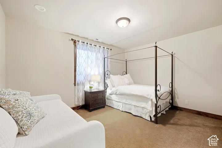 Neutral wall tones, carpeted flooring, recessed lighting, flush-mount ceiling fixture, and a window with wood-trim casing