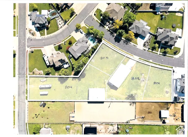 Aerial view of subdivided residential lots featuring expansive grass-covered terrain, clearly defined property boundaries, and direct street frontage