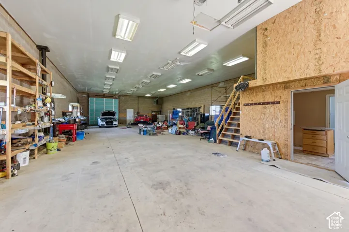 Expansive garage featuring a high-clearance ceiling, recessed fluorescent lighting, concrete flooring