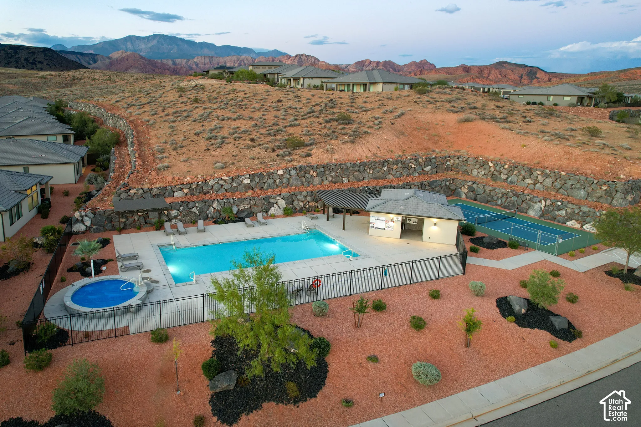 Community recreation area featuring a swimming pool, attached hot tub, covered pavilion, tennis court, and mountain backdrop