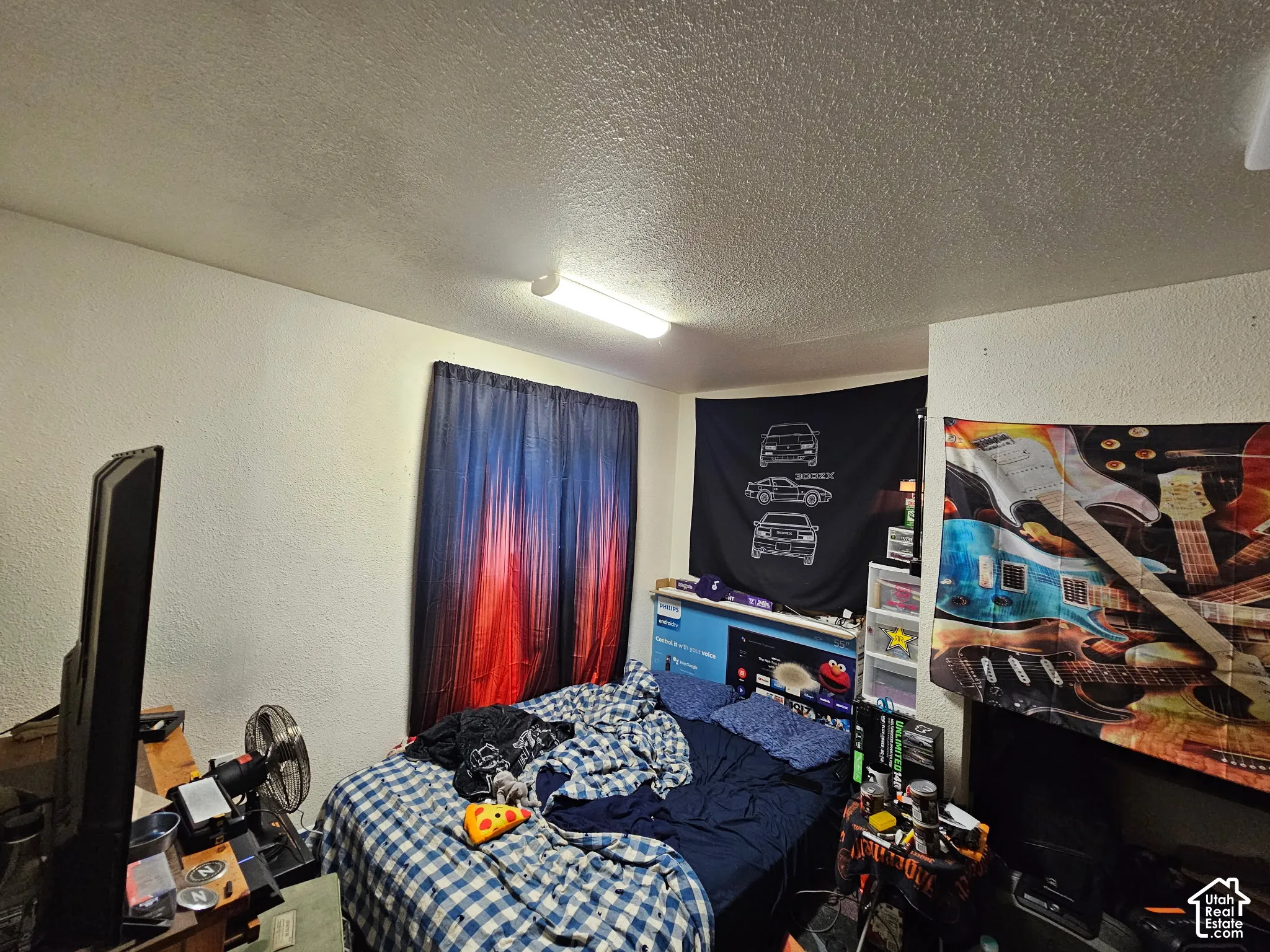 Textured walls, ceiling-mounted linear lighting fixture, and window with textile treatment