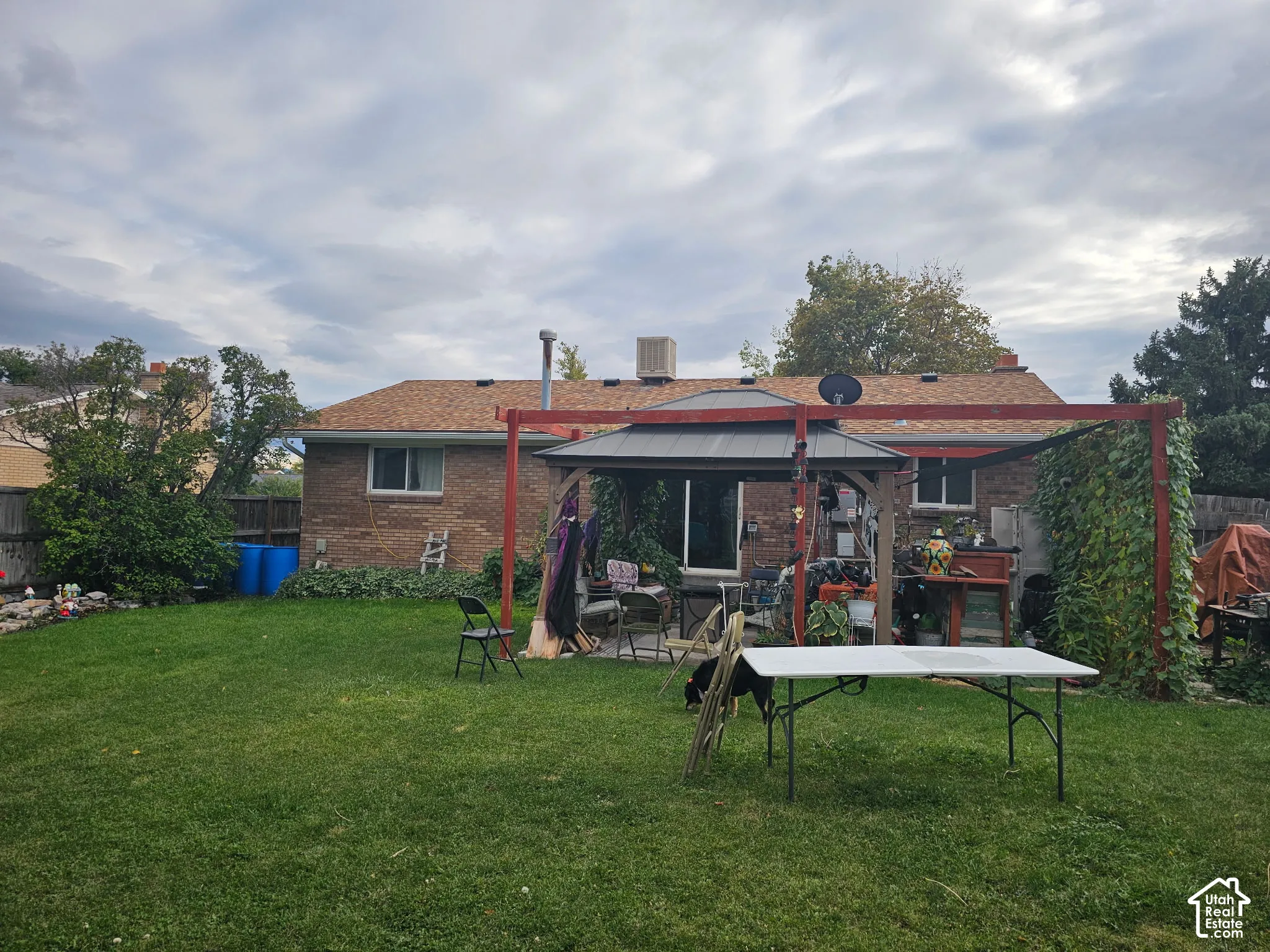 Brick exterior, backyard space, and permanent wooden pergola structure